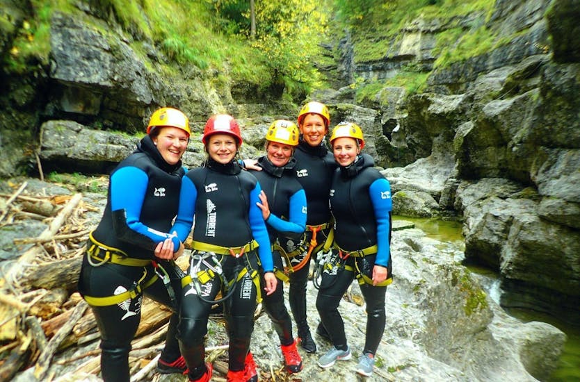 A group of friends is posing for a picture in the canyon during the Full Day Bachelor Party: Rafting Salzach & Canyoning Almbach with Torrent Outdoor Experience.