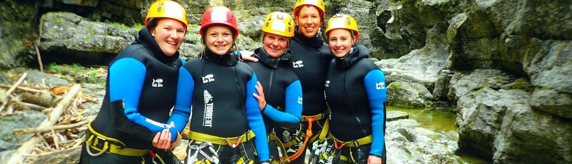 Eine Gruppe von Freundinnen posiert während des ganztägigen Junggesellenabschieds: Rafting Salzach & Canyoning Almbach mit Torrent Outdoor Experience für ein Foto in der Schlucht.