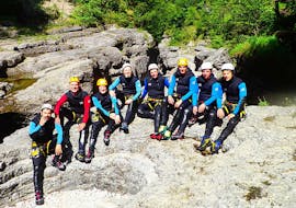 Eine Gruppe von Freunden, die sich nach ihrer abenteurerlichen Canyoning Tour in der Almbachklamm für Jungesell(inn)enabschiede mit Torrent Outdoor Experience auf einem großen Felsen ausruht.