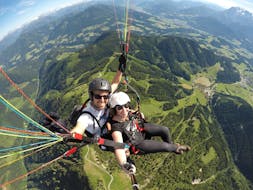 De piloot en een klant zweven door de lucht tijdens hun Tandem Paragliding vanaf Bischling in Werfenweng - Panorama met Flugschule Austriafly Werfenweng.