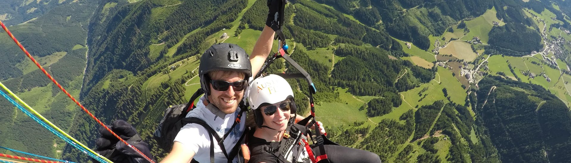 The pilot and a costumer gliding through the air during their Tandem Paragliding from Bischling in Werfenweng - Panorama with Flugschule Austriafly Werfenweng.