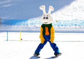 Ein Maskottchen zeigt das Skifahren während des Kinderskikurses "Bolgen" (8-12 J.) für Fortgeschrittene mit der Schweizer Skischule Davos.