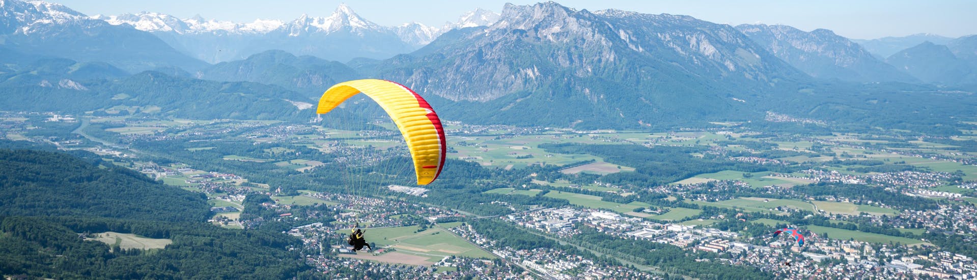 Ein Guide und ein Teilnehmer machen ein Foto während des Tandem-Gleitschirmfliegens in Salzburg Stadt - Classic mit FlyTandem Salzburg.