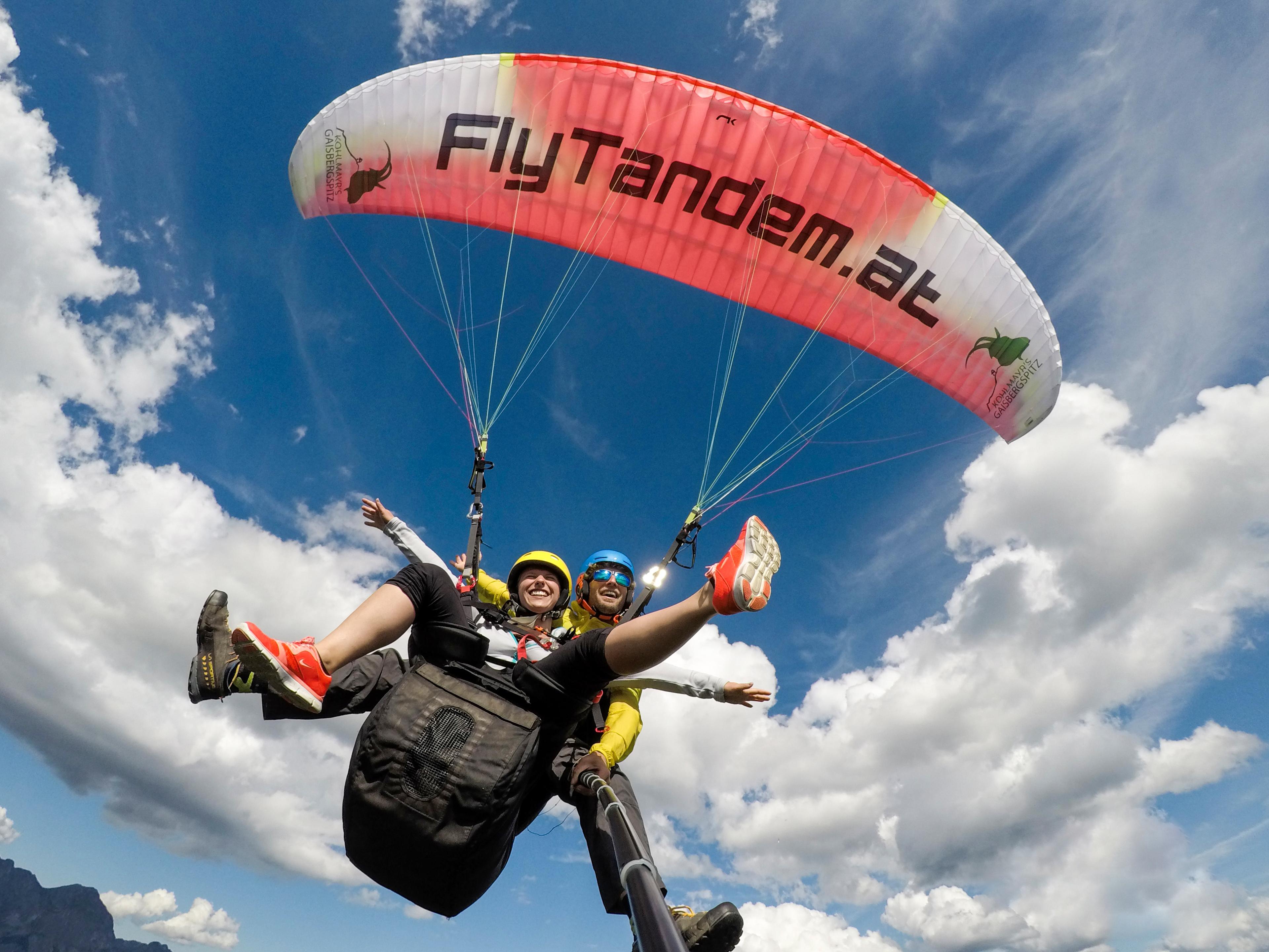 A guide and a participant are in the air and take a photo during tandem paragliding in Salzburg City - Classic Plus with FlyTandem Salzburg.