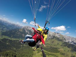Foto eines Guides mit einer Teilnehmerin in der luft beim Tandem Paragliding vom Bischling in Werfenweng - Classic mit FlyTandem Salzburg.