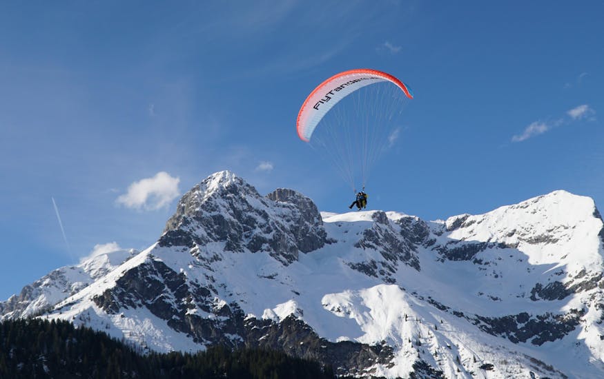 Foto eines Guides mit einer Teilnehmerin in der luft beim Tandem Paragliding vom Bischling in Werfenweng - Classic mit FlyTandem Salzburg.