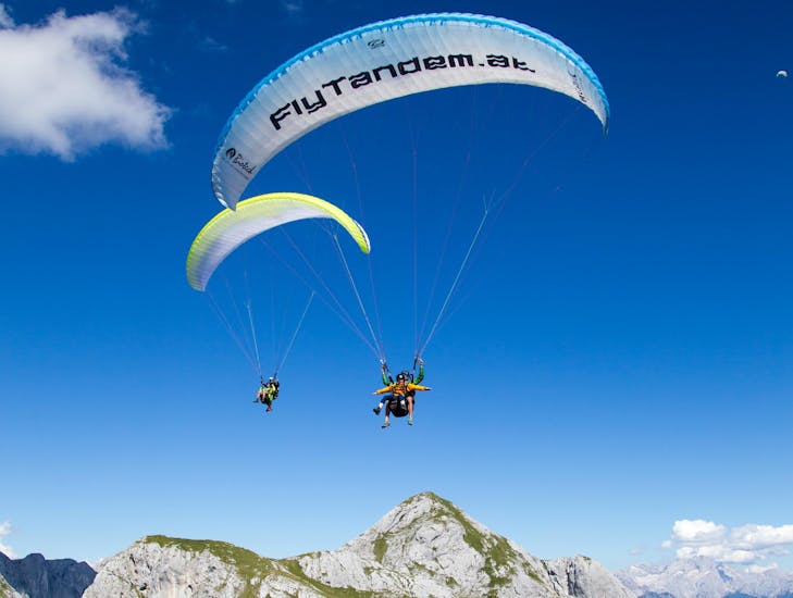 Guide and participant are in the air during tandem paragliding from the Bischling in Werfenweng - Premium with FlyTandem Salzburg.