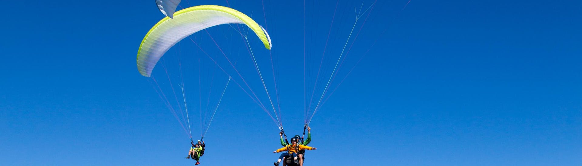 Guide and participant are in the air during tandem paragliding from the Bischling in Werfenweng - Premium with FlyTandem Salzburg.