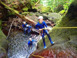 A child is going down a waterfall during his Canyoning in Galion river - Ti-Canyon activity with Vert Intense.