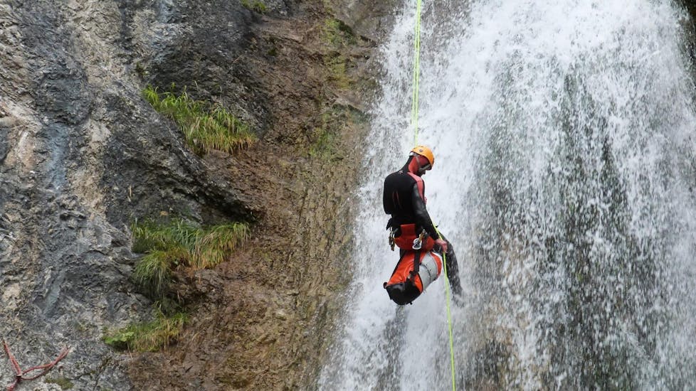 A guy is abseiling down a rock during the Canyoning "Redfox Short" - Enns Valley under the supervision of an experienced canyoning guide from best adventure company.