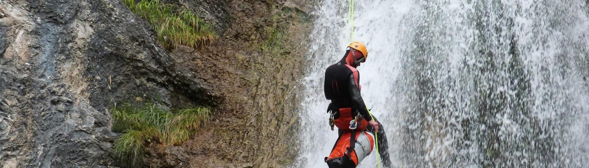 A guy is abseiling down a rock during the Canyoning "Redfox Short" - Enns Valley under the supervision of an experienced canyoning guide from best adventure company.