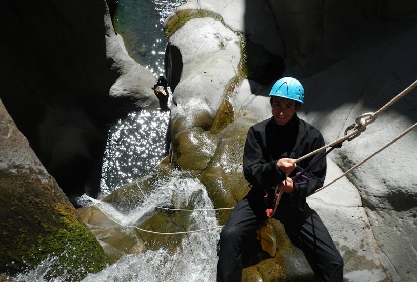 Un participant à la sortie Canyoning dans le canyon de Fleur Jaune - L'incontournable avec Cilaos Aventure descend en rappel dans une vasque d'eau claire.