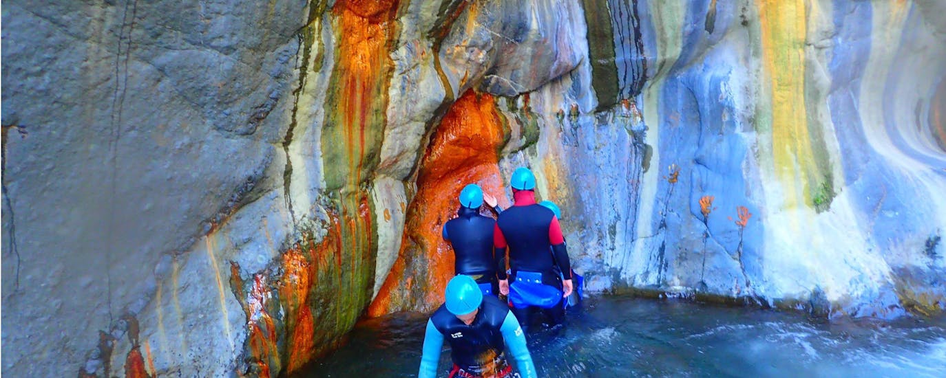 Des participants à la sortie Canyoning dans le canyon Bras Rouge Médian - Aquatique avec Cilaos Aventure s'émerveillent devant la roche multicolore.