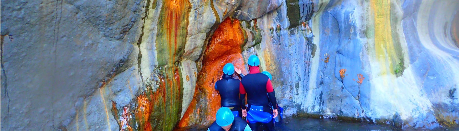 Des participants à la sortie Canyoning dans le canyon Bras Rouge Médian - Aquatique avec Cilaos Aventure s'émerveillent devant la roche multicolore.
