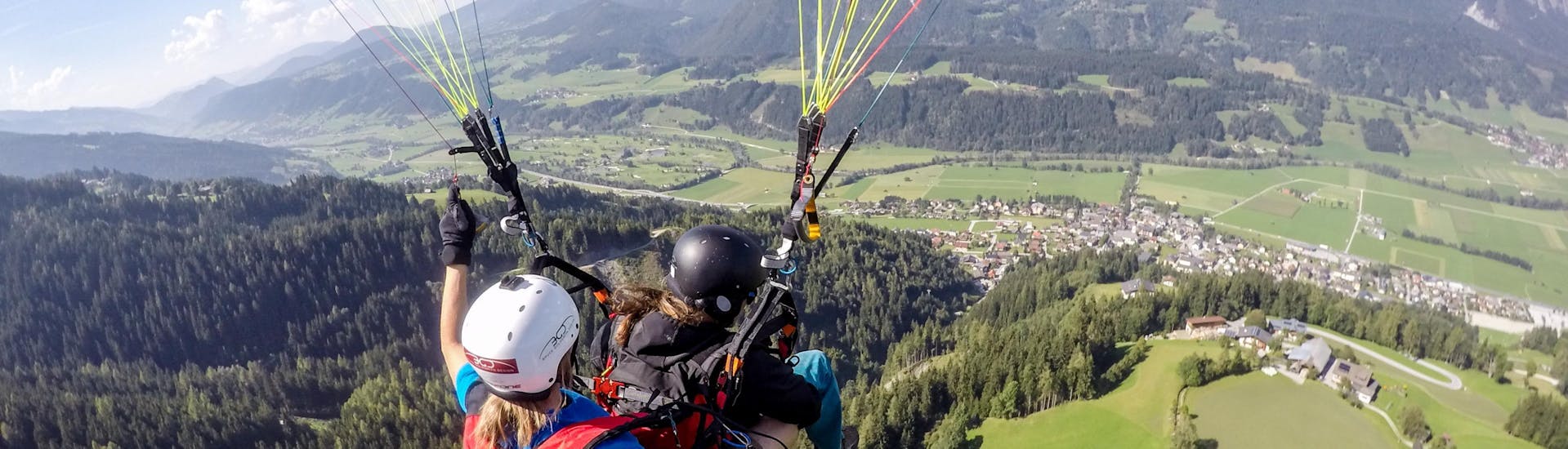 A tandem paraglider enjoying the flight with Flugschule Sky Club Austria Gröbming while Tandem Paragliding from Michaelerberg - First Flight.