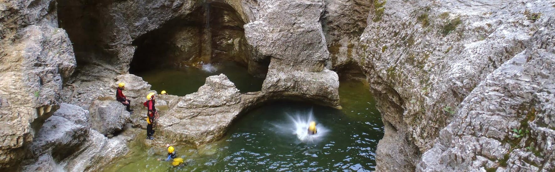 Persoon die in het water springt bij Canyoning in Almbachklamm - Zwitserse kaastocht met Crocodile Sports Salzburg.