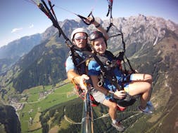 De piloot en een meisje genieten van het uitzicht tijdens het tandem paragliden in Werfenweng vanaf Bischling met Parataxi Werfenweng.