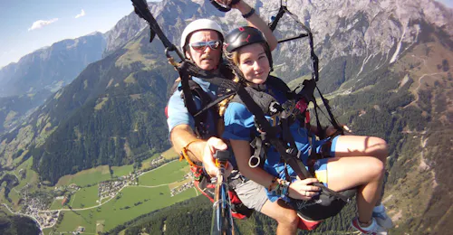 Tandem Paragliding in Werfenweng from Bischling with Parataxi Werfenweng The Pilot and a girl enjoying the view during Tandem Paragliding in Werfenweng from Bischling with Parataxi Werfenweng