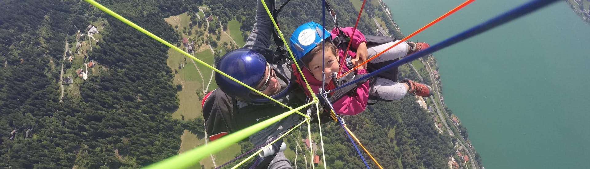 Piloot boven het meer tijdens tandem paragliden boven de Ossiacher See - Actievlucht met Flycenter Ossiachersee