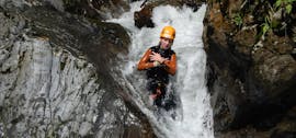 A person sliding down a waterfall while fun canyoning near Lake Weissensee in Carinthia with ARES Drautal Canyoning