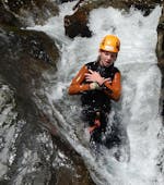 Eine Person rutscht einen Wasserfal hinunter beim Fun Canyoning nahe des Weißensees in Kärnten mit ARES Drautal Canyoning
