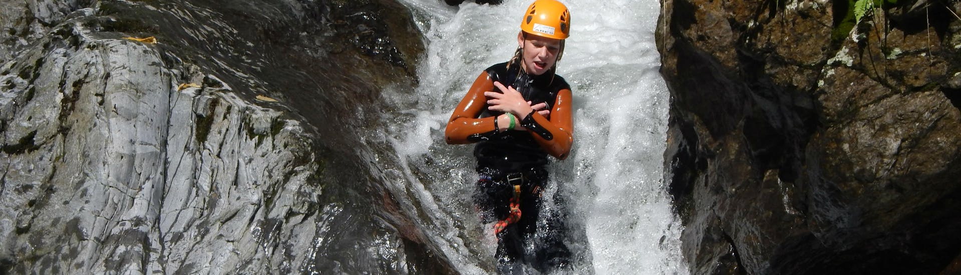Een persoon glijdt van een waterval tijdens fun canyoning bij de Weissensee in Karinthië met ARES Drautal Canyoning