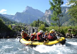 A group of friends is paddling in a beautiful wilderness scenery during their Rafting on Giffre River - Classic with Raft Rider.