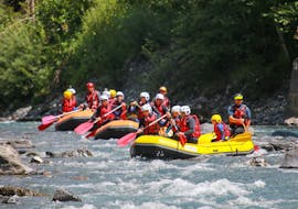 A group of friends is paddling in a beautiful wilderness scenery during their Rafting on Giffre River for Groups (10+ people) - Classic with Raft Rider.