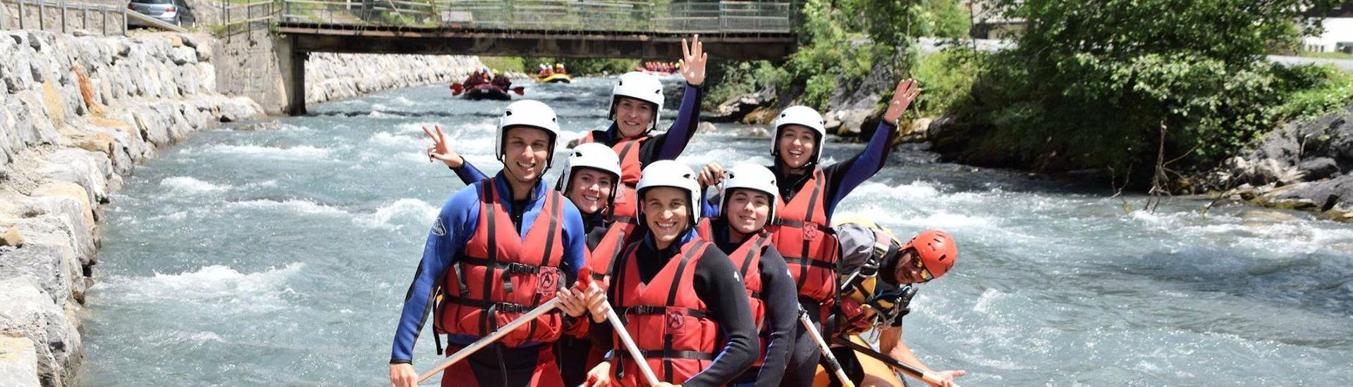A group of friends is paddling in a beautiful wilderness scenery and having fun during their Rafting on Giffre River - Full Descent with Raft Rider.