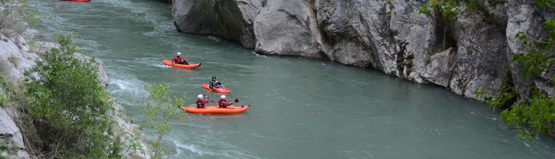 Eine Gruppe von Leuten paddelt beim Kanu-Rafting auf dem Noguera Pallaresa mit La Rafting Company den Fluss entlang.