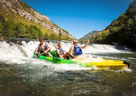 A family is having fun crossing one of the rapids of the Tarn during their 10km Canoe Tour in Gorges du Tarn with Le Soulio.