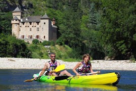 Ein Paar paddelt vor einer der Burgen, die man auf der 21 km langen Kanutour in den Gorges du Tarn mit Le Soulio sehen kann.