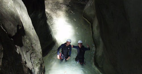 Barranquismo para principiantes en el Barranco de Sant Pere con La Rafting Company Sort Una pareja se encuentra en un río subterráneo en el Barranco Sant Pere y sonríe a la cámera durante el Canyoning Principiantes con La Rafting Company.