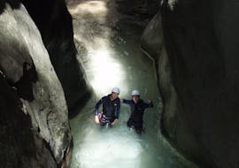 Una pareja se encuentra en un río subterráneo en el Barranco Sant Pere y sonríe a la cámera durante el Canyoning Principiantes con La Rafting Company.