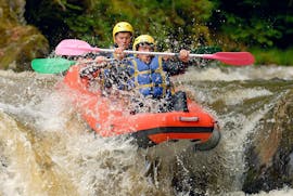 Two friends are facing the impetuous current of the river during their Rafting on Le Chalaux River - Hot-Dog tour with AN Rafting Morvan.