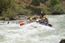Los participantes del tour reman junto con un guía de OcioAventura Cerro Gordo a través del Río Genil durante la ruta del rafting tramo de aguas bravas.