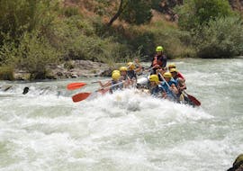 The tour participants paddle together with a guide from OcioAventura Cerro Gordo through the Rio Genil during the rafting whitewater trail.