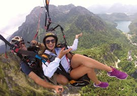 A passenger and her tandem pilot from Flugschule Aktiv are soaring high above Schwangau during the Tandem Paragliding over Neuschwanstein Castle from Tegelberg.