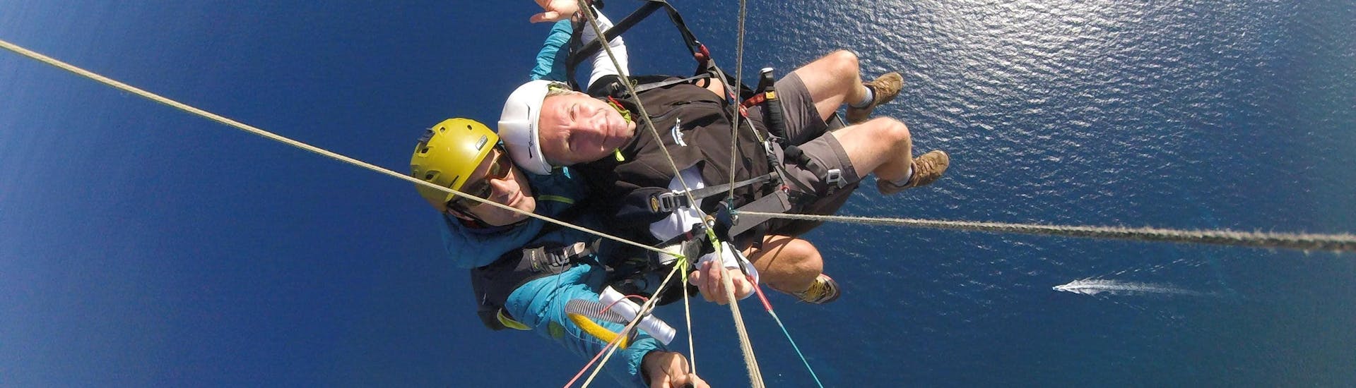 Un pilote de parapente de Saint Leu Parapente effectue un vol tandem parapente - Découverte 20min au-dessus de la Baie de Saint Leu à La Réunion.