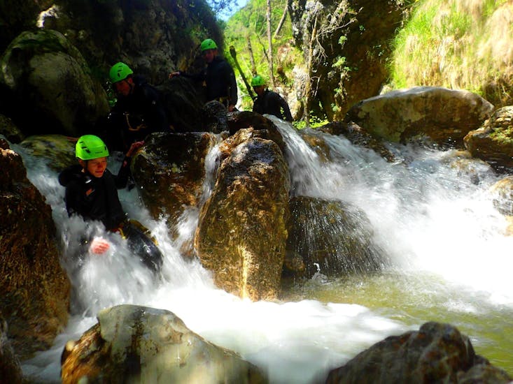 The group of participants of the Canyoning at Torrente Toscolano - Summerrain organized by Skyclimber fprocede in the torrent between the rocks.