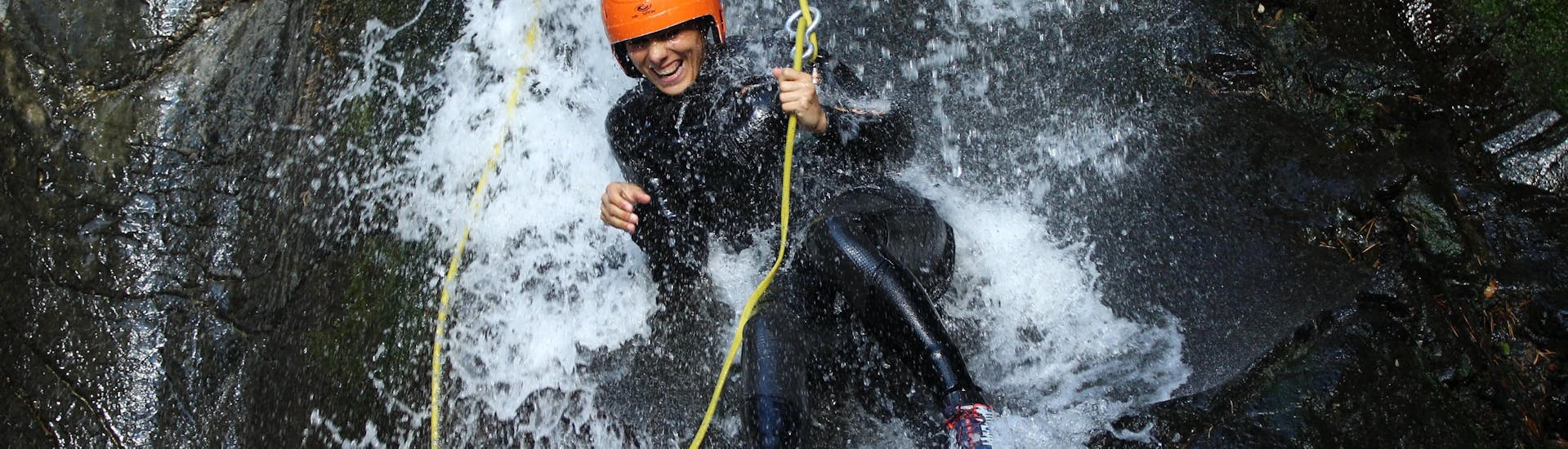 Una donna scende dalle rocce acquatiche mentre fa canyoning con ROCROI.
