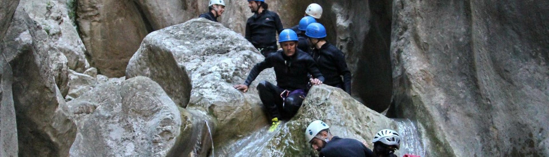 Eine Gruppe von Menschen steigt bei ihrem Canyoning im Barranco del Infierno mit ROCROI vorsichtig und gekonnt die Felsen hinab, um das nächste Becken zu erreichen.