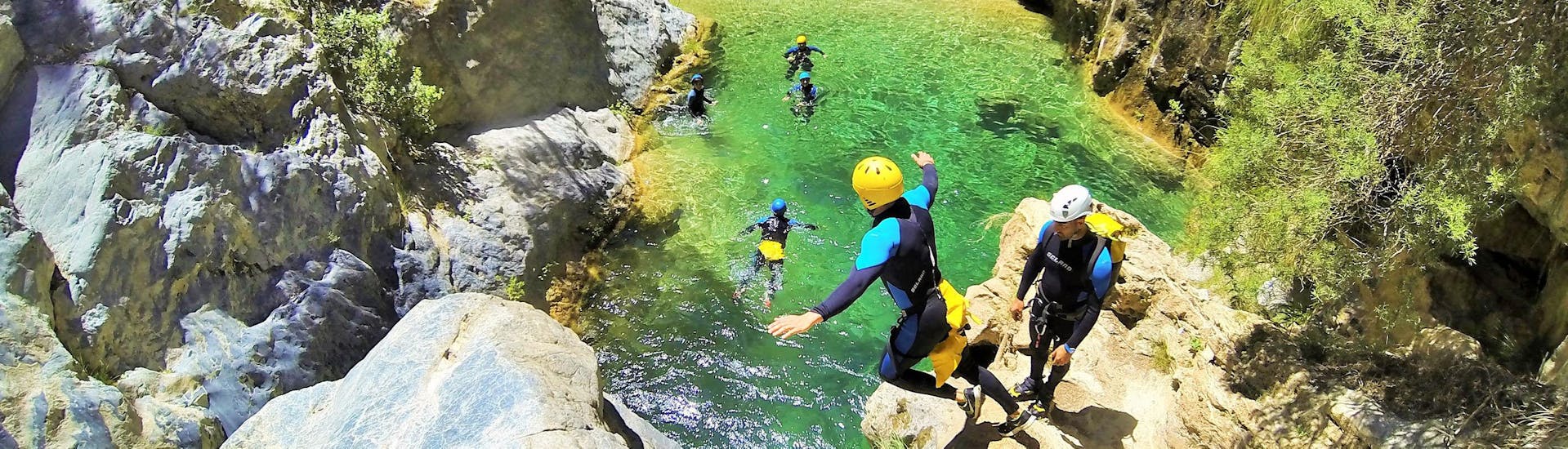 Eine Gruppe von Freunden springen von der Klippe ins glasklare Wasser während der Canyoning Anfänger Tour im Rio Verde, organisiert von Barranquismo Rio Verde.