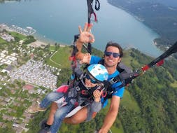A kid is having her Tandem Paragliding at Lake Annecy for Kids (3 -12 years) activity with FBI Parapente.