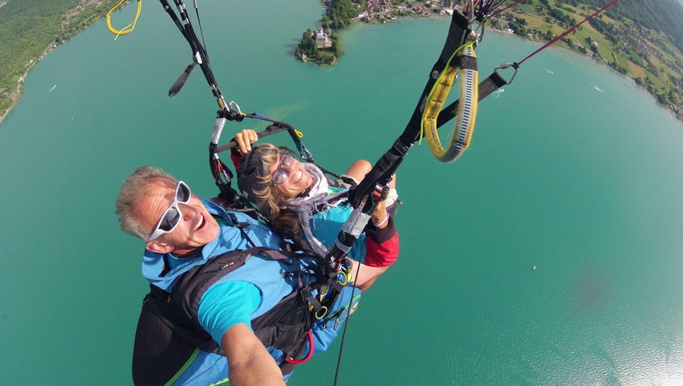 Een dame geniet van haar tandem paragliding bij het meer van Annecy - Ascendance-activiteit met FBI Parapente.