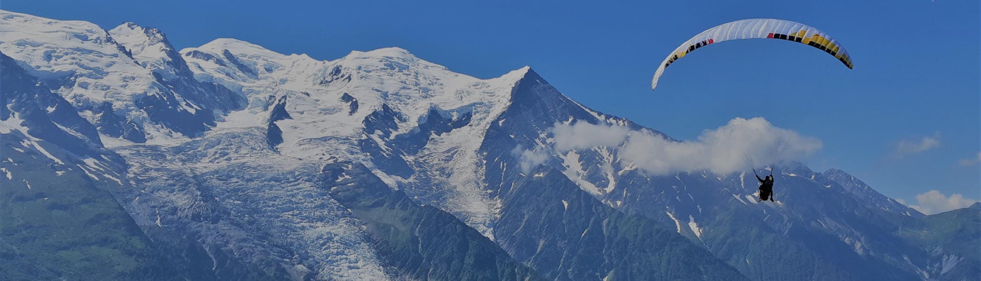 A person is flying during his Tandem Paragliding at Plan de l'Aiguille - XXL activity with Les Ailes du Mont Blanc.