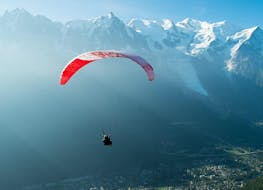 A paragliding pilot from Kailash Paragliding is doing a Tandem Paragliding Flight from Plan de l'Aiguille above the Chamonix Valley.