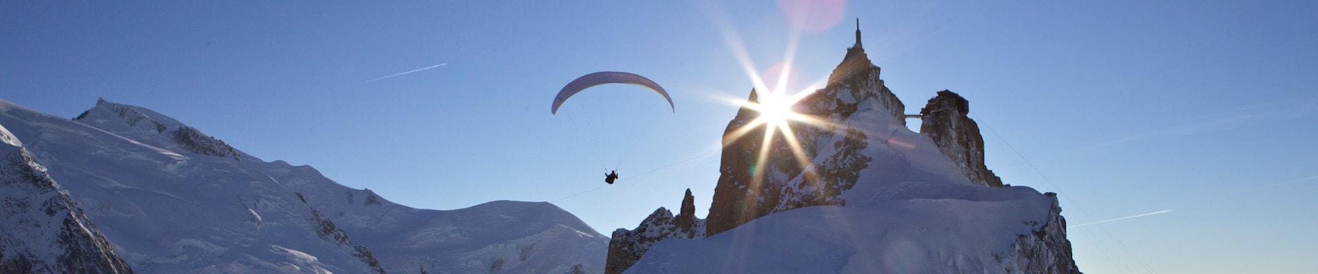 A paragliding pilot from Kailash Paragliding is doing a Tandem Paragliding Flight from the Aiguille du midi against a mountain backdrop.