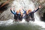 Un grupo de amigos que participan en el barranquismo intermedio en el cañón de Montmin, con Térreo Canyoning, está disfrutando de la cascada.