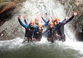 A group of friends participating to Canyoning "Sensation" - Canyon de Montmin with Térreo Canyoning are enjoying the waterfall.